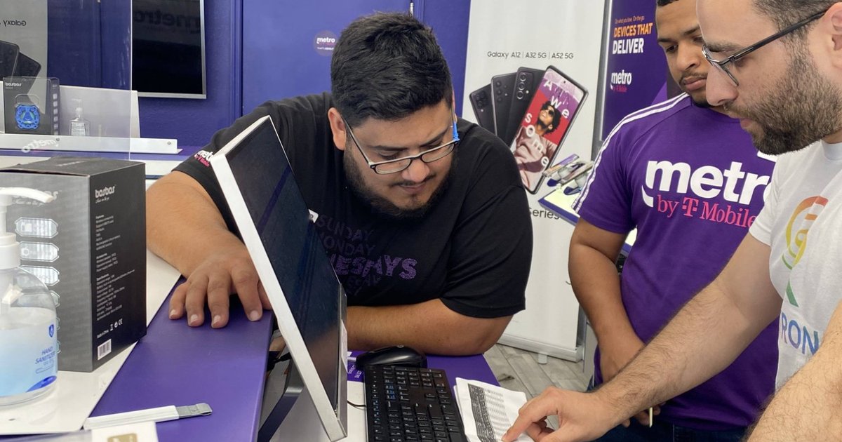 Evan Ross walking a Celltronix team member through a printed process sheet at the store counter